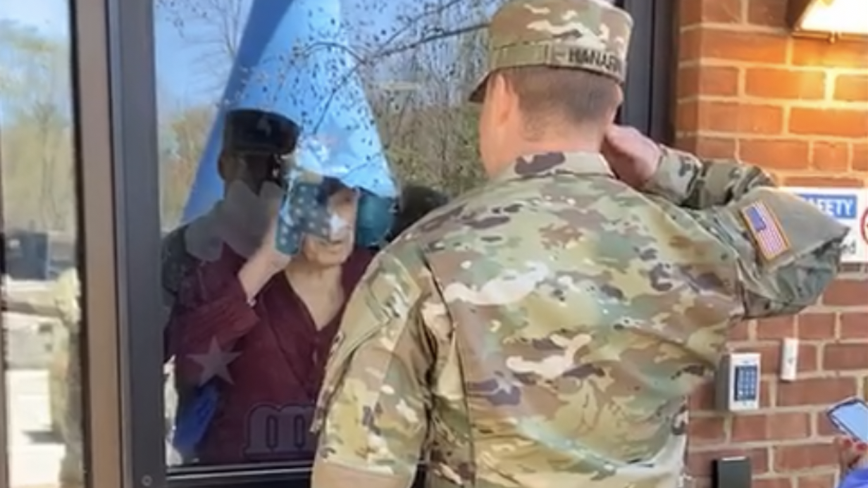 Newly Commissioned Lieutenant Gives First Salute to Grandpa Behind a Pane of Glass